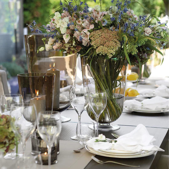 Table setting with vases with flowers and smaller ones with candles